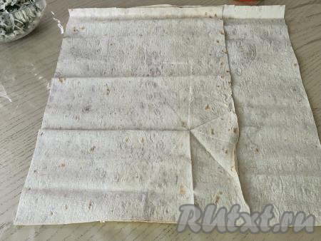 Лаваш разрезать пополам. Получившиеся 2 листа лаваша выложить один на другой немного внахлёст, как на фото.