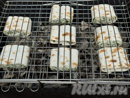 Мангал заранее подготовить, в нём должны быть хорошо разогретые угли, прямого огня быть не должно. Выложить рулеты из лаваша с сырной начинкой на решётку мангала.&nbsp;