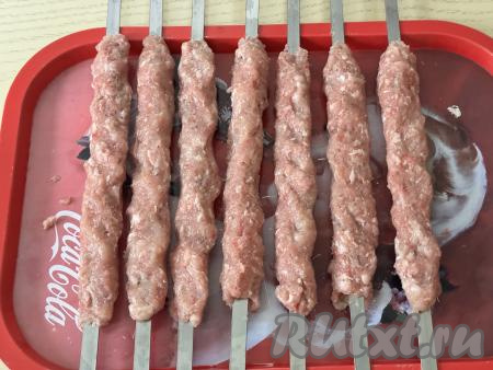 Накрыть миску с фаршем крышкой и отправить в холодильник минимум на 1 час. Затем разделить фарш на 7 равных частей. Смочив руки водой, сформировать из каждой части фарша люля-кебаб на шампуре. Постепенно сформировать все 7 заготовок люля-кебабов из свинины и курицы на шампурах.