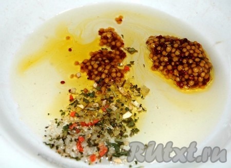 Приготовить смесь для смазывания (обмакивания) филе сельди. Для этого соединить в тарелке подсолнечное и оливковое масло, зерновую горчицу и соль со специями. Размешать все, чтобы получилась однородная масса.