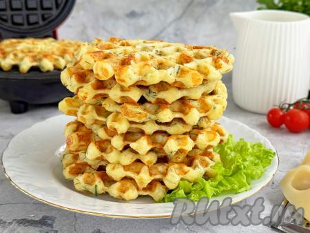 Периодически перемешивания сырное тесто и смазывая по мере необходимости створки вафельницы маслом, постепенно испечь все вафли. Из предложенного количества ингредиентов у меня получились 13 вкусных, мягких, нежных вафель с сыром и зеленью. Их можно подать и к чаю, и в качестве достаточного сытного перекуса.