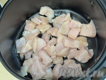 Снять решётку из чаши аэрогриля. Влить в чашу растительное масло, выложить куриное филе, нарезанное на небольшие кубики.