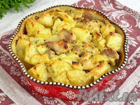 Готовое блюдо достать из духовки. Картошка получается мягкой, аппетитной, кусочки филе бёдер курицы - сочными, нежными.