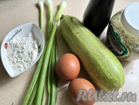 Подготовить продукты для приготовления кабачковых оладий в аэрогриле. Кабачок лучше использовать молодой, то есть с мягкой кожицей и мелкими семечками. У молодого кабачка нужно будет отрезать "кончики" с двух сторон, от кожуры его можно не очищать, достаточно тщательно промыть водой. Если вы возьмёте кабачок с толстой кожурой и крупными семечками, тогда семечки нужно будет удалить, а кожуру - срезать. Свежую зелень (у меня - зелёный лук, но можно взять и укроп или петрушку) промыть водой. 