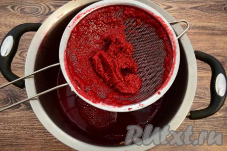 Для того чтобы избавиться от косточек, протереть слегка остывшее малиновое пюре через сито с помощью ложки в кастрюлю. Всё пюре у меня в сито сразу не поместилось, поэтому я протирала частями, периодически выбрасывая из сита практически сухие косточки.&nbsp;