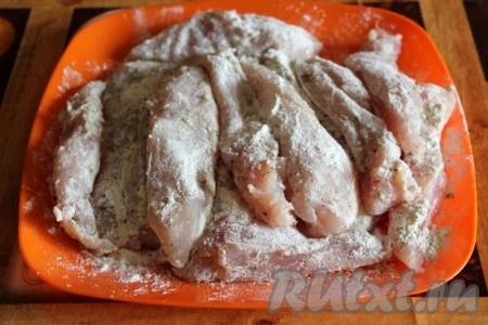 Куриное филе нарежьте на продолговатые кусочки, обваляйте их в смеси муки и сухих прованских трав, посолите.