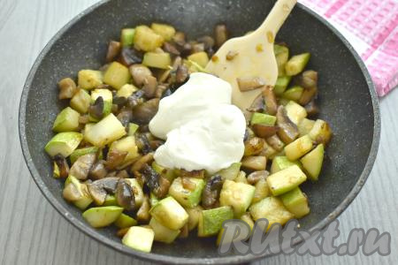 К кабачкам, обжаренным с шампиньонами, добавляем сметану (я взяла сметану жирностью 20%, но можно взять любой жирности), перемешиваем, обжариваем 2-4 минуты, периодически помешивая, затем убираем с огня.