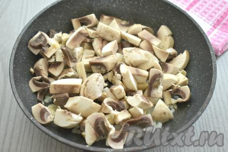 К обжаренному луку выкладываем шампиньоны, нарезанные на средние кусочки, перемешиваем и обжариваем 6-7 минут, время от времени перемешивая.