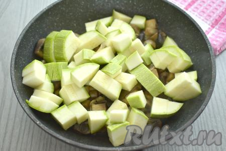 Пока обжариваются грибы, займёмся кабачком. Если у него мелкие семечки и тонкая кожура, тогда семечки можно не удалять, кожуру можно не срезать, достаточно будет отрезать кончики у кабачка с двух сторон и вымыть его. Если же у кабачка толстоватая кожура, тогда её нужно обязательно срезать, крупные семечки нужно будет удалить. 300 грамм подготовленного кабачка нарезаем на небольшие кубики. После того как шампиньоны с луком обжарятся 6-7 минут, добавляем в сковороду кабачки.