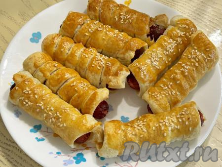 Готовые сосиски в тесте достать из аэрогриля, переложить на тарелку. Аналогично запечь в аэрогриле оставшиеся сосиски в слоёном тесте. Выпечка получается аппетитной.