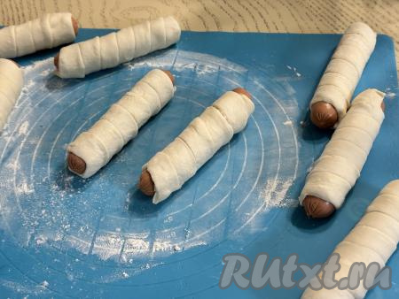 Таким образом каждую сосиску обмотать одной полоской из теста.