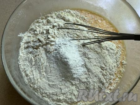 Всыпать 100 грамм просеянной муки, весь разрыхлитель и щепотку соли, перемешать венчиком.&nbsp;