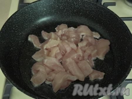 Куриное филе нарезать на брусочки, посолить, перемешать. В сковороду с высоким бортиком влить растительное масло, хорошо его разогреть, выложить кусочки мяса курицы.
