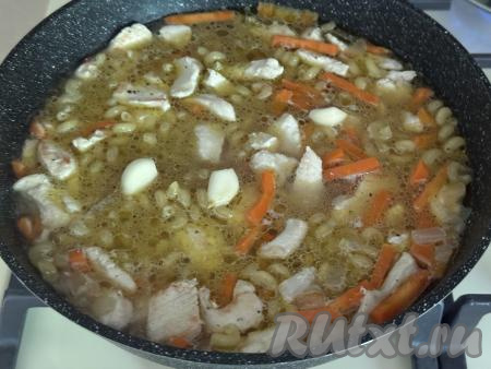 Перемешать макароны с курицей и овощами. Выложить очищенные зубчики чеснока. Дать воде закипеть, накрыть сковороду крышкой. Готовить плов из макарон с курицей&nbsp;на минимальном огне 15 минут.