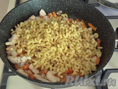 Всыпать в сковороду сухие макароны.