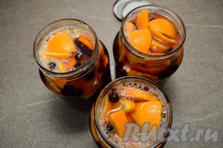 Горячий сироп сразу разлить по банкам с апельсинами и смородиной, заполняя баночки до самого верха.