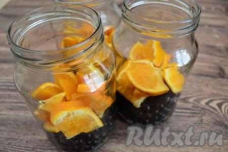 Нарезанный апельсин равномерно разложить по трём банкам поверх смородины.