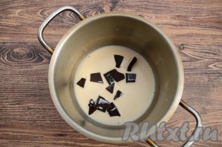 В небольшую кастрюльку (или ковшик) влить 50 миллилитров молока, добавить поломанный на небольшие кусочки шоколад, поставить на средний огонь.