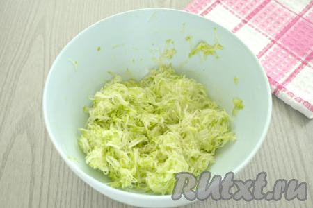 Кабачок моем. Если у кабачка толстая кожура, её нужно срезать. Если семечки у кабачка крупные, их тоже нужно будет удалить. Если же вы взяли кабачок с тонкой кожицей и мелкими семечками, тогда можно просто вымыть кабачок, обрезать кончики с двух сторон. В миску натираем 250 грамм подготовленного кабачка. Затем тщательно отжимаем натёртый кабачок от лишнего сока. Для этого можно брать частями в руки натёртый кабачок и тщательно отжимать кабачковую массу от лишней жидкости (эта жидкость нам больше не понадобится). Выкладываем кабачковую массу, отжатую от лишней жидкости, в объёмную миску.