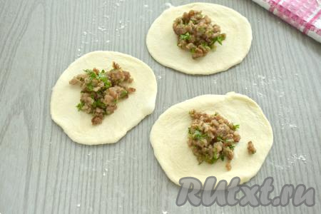 Заготовки из теста раскатываем в лепёшки диаметром ориентировочно 8-9 сантиметров. В центр каждой лепёшки выкладываем 1 столовую ложку остывшего фарша.