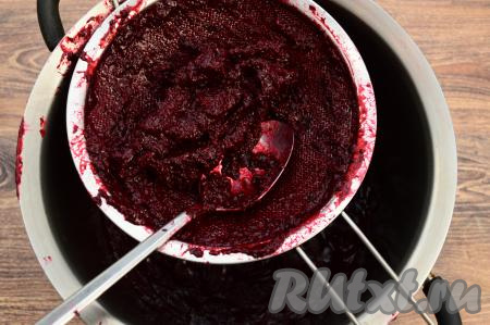 Для того чтобы убрать косточки и шкурки, нужно протереть ягодное пюре через сито (или специальное сито для перетирания фруктов и ягод). Для этого нужно взять отдельную кастрюлю, поверх неё поставить сито, частями выкладывать пюре в сито  и перетирать его с помощью столовой ложки в кастрюлю. Это недлительный процесс, но, пожалуй, один из самых трудоёмких в этом рецепте. В сите у меня оставался практически сухой жмых, а в кастрюле было однородное смородиновое пюре. Практически сухого жмыха (то есть косточек и кожуры) в сите остаётся достаточно много, при желании из жмыха можно сварить компот.&nbsp;