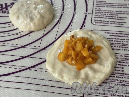 Каждый кусочек теста на столе, присыпанном мукой, растянуть в лепёшку. В центр каждой лепёшки выложить 1 столовую ложку начинки.