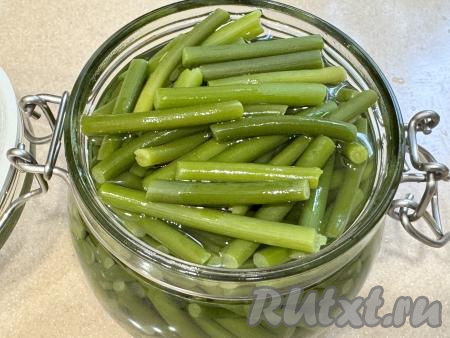 Полностью залить отваренные чесночные стрелки горячим маринадом и оставить на 1 час при комнатной температуре, а затем закрыть крышкой и убрать в холодильник на 5-6 часов.&nbsp;