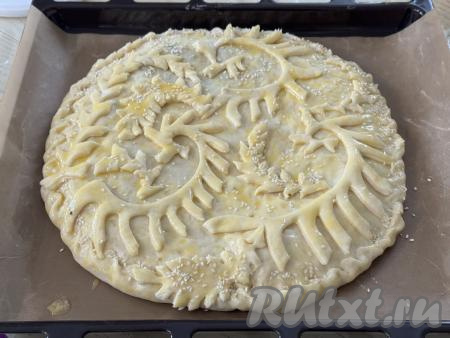 Оставить пирог на 20 минут на кухонном столе. Яичный желток, который оставляли в процессе замешивания теста, взбить вилкой. После того как пирог постоит на столе 20 минут, смазать его взбитым желтком, по желанию, присыпать кунжутом. Поставить пирог с минтаем в разогретую до 180 градусов духовку, выпекать минут&nbsp;30 (до подрумянивания дрожжевого теста).&nbsp;