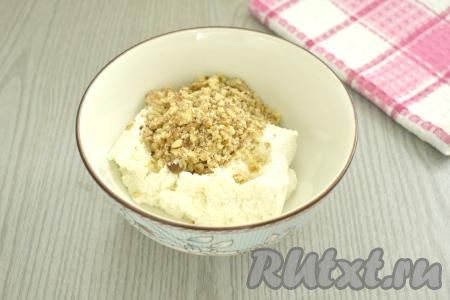 Пока присоленные баклажаны "отдыхают", подготовим творожную начинку для рулетиков. Для этого творог любой жирности выкладываем в миску, разминаем его вилкой (или протираем через сито). Очищенные орехи рубим ножом на мелкие кусочки, выкладываем в миску с творогом.