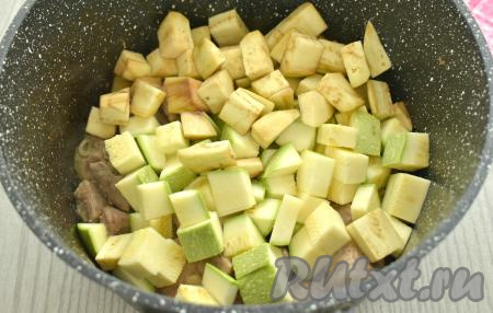 Баклажан очищаем от кожуры, нарезаем на небольшие кубики. Кабачок я взяла молодой, то есть с тонкой кожурой и мелкими семечками, поэтому просто вымыла его и обрезала кончики с двух сторон (очищать от кожуры и семечек я его не стала). Если же вы будете использовать кабачок с толстой кожурой, тогда кожуру нужно будет срезать, крупные семечки нужно будет удалить. 400 грамм подготовленного кабачка нарезаем на небольшие кубики. Нарезанные баклажаны и кабачки выкладываем к свинине, протушившейся в течение 15 минут.