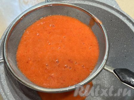 Взять кастрюлю с толстым дном, поверх неё поставить сито. Откинуть получившееся клубничное пюре на сито. Тщательно перетереть ягодное пюре через сито. В кастрюле у нас будет пюре из клубники без косточек. А в сите останется практический сухой жмых, который нам не понадобится.