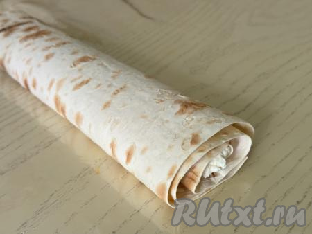 Завернуть лаваш с начинкой в рулет. Я края лаваша не подгибала, так как начинка достаточно густая и она не будет вытекать в процессе выпечки рулета.