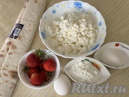 Подготовить продукты для приготовления рулета из лаваша с клубникой и творогом. Творог можно использовать любой жирности и консистенции. Крахмал можно взять как картофельный, так и кукурузный. Эту простую выпечку можно приготовить и со свежей клубникой, и с замороженной. Свежие ягоды нужно будет вымыть, удаляя чашелистики. Замороженную клубнику, если на ней нет большого количества льда, нужно слегка разморозить.&nbsp;