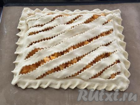 Аккуратно выложить тесто с разрезами поверх абрикосовой начинки. Хорошо скрепить края двух пластов теста по всему краю пирога. Дать пирогу 20-25 минут постоять, чтобы дрожжевое слоёное тесто подошло.