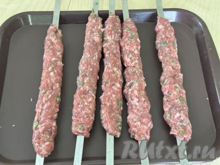 Поставить фарш в холодильник на час.&nbsp;Затем разделить фарш из говядины на 5 равных частей и, смочив руки холодной водой, сформировать люля-кебабы, растягивая фарш по длине каждого шампура.