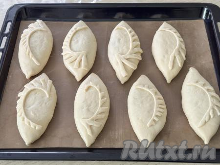 8 сформированных пирожков с лисичкой и картошкой выложить на противень, застеленный пергаментом (или ковриком) для выпечки. Из отложенного небольшого количества теста можно сформировать узоры и выложить поверх каждого пирожка.