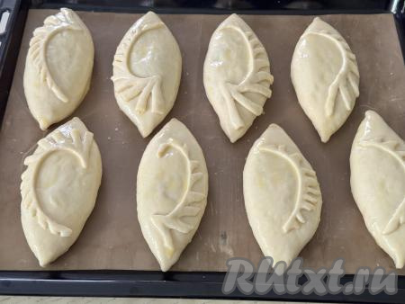 Оставить пирожки с лисичками и картошкой&nbsp;под полотенцем на 20 минут для подхода дрожжевого теста. Яичный желток, который мы откладывали для смазывания пирожков, в небольшой ёмкости взбить вилкой до однородности. Смазать каждый пирожок взбитым желтком.