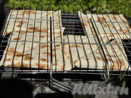 Выложить треугольники из лаваша с сыром в один слой на решётку для жарки на мангале.