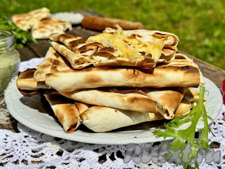 Готовые треугольники из лаваша с сыром переложить&nbsp;с решётки мангала на тарелку и сразу, с пылу с жару, подать к столу. Сочетание горячего тянущего сыра и приятно похрустывающего лаваша - это очень вкусно!