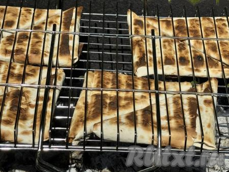 Жарить треугольники, используя жар углей, минут 5, часто переворачивая решётку, чтобы лаваш равномерно подрумянился, а сыр внутри расплавился. 