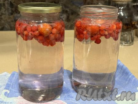 Горячим сиропом заполнить банки с клубникой и смородиной до самого верха. Закрутить (или закатать) банки с компотом простерилизованными крышками.