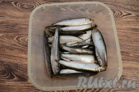 Размороженную кильку сложить в контейнер.