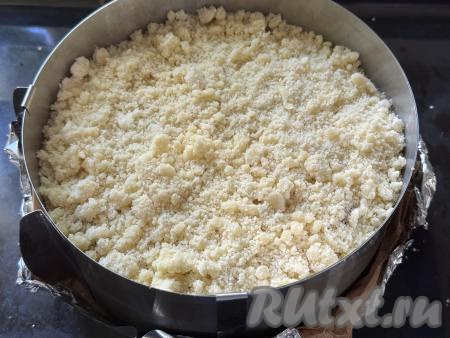 Равномерно разложить отложенную ранее песочную крошку поверх творожно-клубничного слоя.&nbsp;