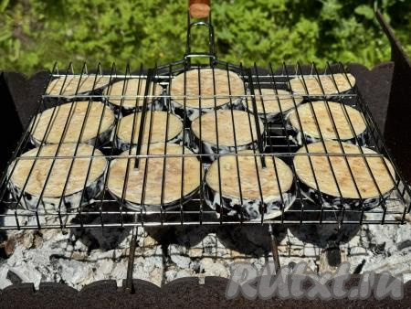 Поместить решётку с баклажанами на мангал с раскалёнными углями. Прямого огня в мангале быть не должно.