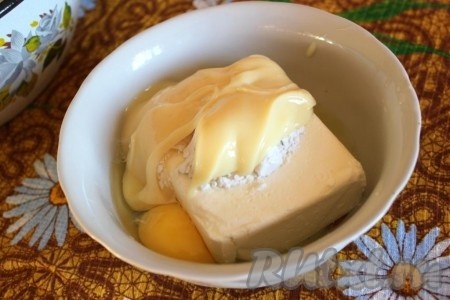 Пока тесто охлаждается, займёмся начинкой. 100 грамм масла подогрейте в микроволновке. Масло должно хорошо размягчиться, полностью растапливать до жидкого состояния его не нужно. В ёмкости удобной для взбивания соедините творог, сахар и ванильный сахар, размягчённое сливочное масло, яйца и крахмал, пробейте погружным блендером до однородности.