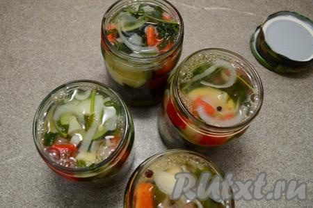 Затем поставить кастрюлю с жидкостью, в которой варились овощи, на сильный огонь, довести до кипения, влить уксус, перемешать, дать закипеть, проварить маринад 2 минуты на небольшом огне. Удалить лавровые листья из маринада. Сразу же разлить горячий маринад по банкам, заполняя баночки до самого верха. Закрутить (или закатать) банки крышками.