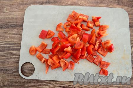 Болгарский перец очистить от семечек и плодоножки, промыть его водой. Нарезать перец на квадратики шириной примерно 1,5-2 сантиметра.