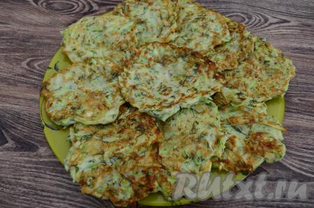 Готовые аппетитные оладьи со сковороды выкладывать на тарелку. Перед выкладыванием очередной порции теста на сковороду обязательно перемешивайте тесто, чтобы оно имело однородную консистенцию. По мере необходимости в сковороду можно добавлять немного растительного&nbsp;масла. Постепенно пожарить все оладьи. Всего у меня получились 10 кабачковых оладий.