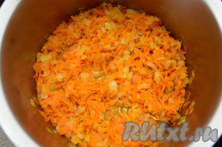 К луку, обжаренному до прозрачности, выложить морковку, натёртую на крупной тёрке, перемешать, обжарить овощи до мягкости моркови (примерно в течение 6-7 минут), время от времени перемешивая.