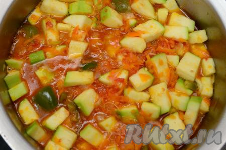 После того как овощи проварятся с помидорами 5 минут, добавить в кастрюлю чеснок и кабачки, хорошо перемешать, дать закипеть, уменьшить огонь. Варить кабачки с овощами в течение 10 минут, периодически перемешивая. Кабачки в процессе варки выделят сок, поэтому постепенно жидкости в кастрюле станет достаточно много.